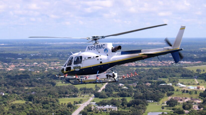 Image of Lee County Mosquito Control helicopter flying above community.